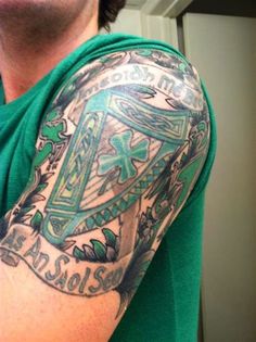 a man with a green shirt has a tattoo on his arm