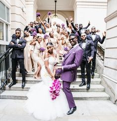 a bride and groom posing on the steps with their bridal party