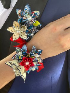 a close up of a person wearing a blue suit and red flowers on their wrist