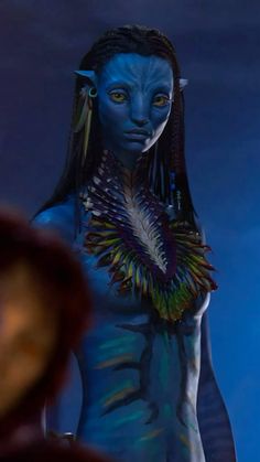 a woman with blue skin and feathers on her body