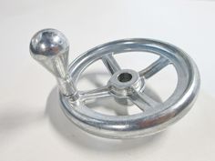 a metal steering wheel on a white surface