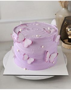 a purple cake with white butterflies on it