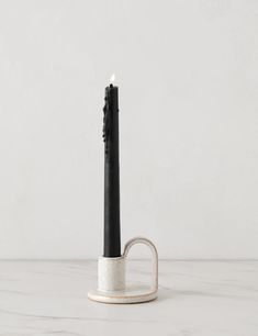 a black candle holder on a white table