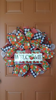 a welcome sign is attached to the front door with an orange and green wreath on it