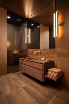 A contemporary bathroom with modern lighting and rich brown tones, exemplifying sleek brown bathroom designs. Modern Brown Bathroom, Bathroom Design