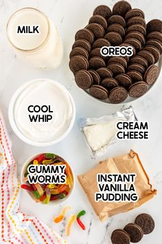 the ingredients for an ice cream sandwich laid out on a marble counter top, including milk, cookies, and gummy worms