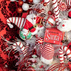 a christmas tree decorated with ornaments and candy canes, including santa's helper ornament