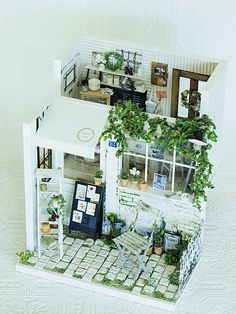 a doll house with plants growing out of the windows and on top of the floor