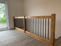 an empty room with wood and metal railings on the wall, next to a sliding glass door