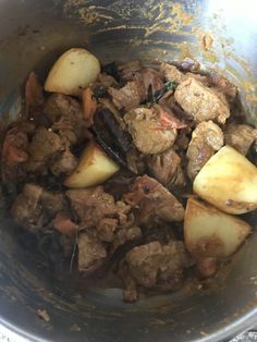 meat and potatoes cooking in a pot on the stove