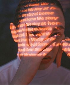 a woman covering her face with hands and glowing words on the screen in front of her