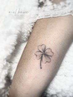 a four leaf clover tattoo on the arm