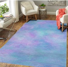 a blue and purple rug in a living room with two white chairs on the floor