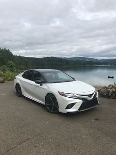 a white car is parked near the water