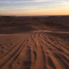 the tire tracks in the sand make it look like they are moving