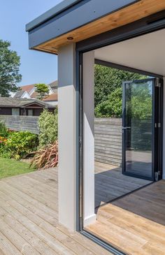 an open patio with sliding glass doors and wooden decking on the side of it