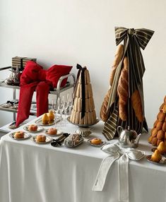 a table topped with pastries and desserts on top of a white table cloth