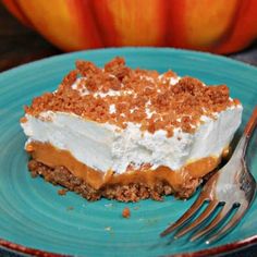 a piece of cake on a blue plate with a fork and an orange pumpkin in the background