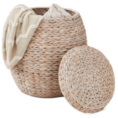 two woven baskets are sitting next to each other, one with a blanket on top