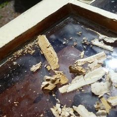 some wood chips are sitting on top of a metal pan and the bottom is dirty