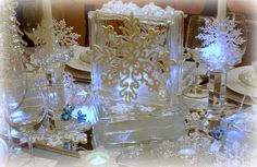 a table topped with lots of glassware and snowflakes on top of it