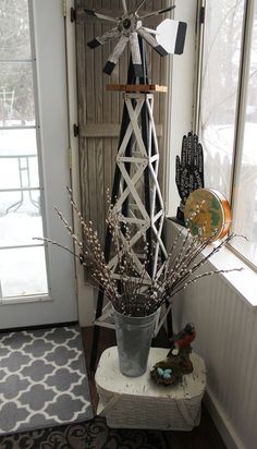 a windmill is sitting on top of a table in front of a window with gloves and other items