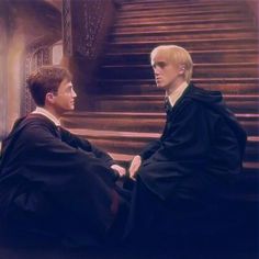 two men in robes sitting on the ground