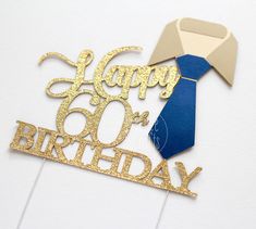 a happy 60th birthday cake topper with a blue tie and gold glitter on it