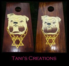 two cornhole boards with dogs on them and the words tan's creations written in gold