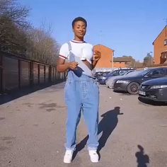 a woman standing in the middle of a parking lot with her hands on her hips