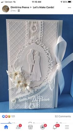 a wedding card with white paper and flowers on the front, featuring an image of a bride and groom