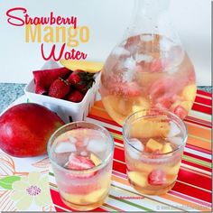 two glasses filled with ice and strawberries next to a pitcher of water on a table