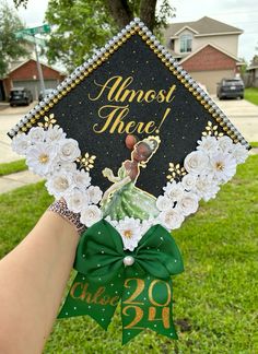 someone is holding up a graduation cap with flowers and the words almost there on it