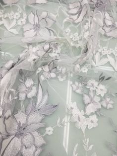 the fabric has flowers on it and is light green with white trimmings,