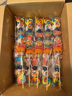 a box filled with lots of colorful lollipops on top of wooden sticks