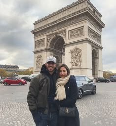 a man and woman standing in front of the arc de trioe, paris france