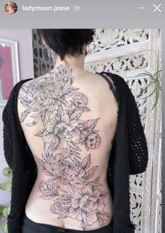 the back of a woman's body with flowers tattooed on her upper and lower back