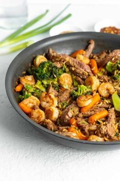 a pan filled with meat and vegetables on top of a table