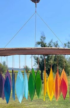 a wind chime hanging in the air with colorful surfboards on it's strings