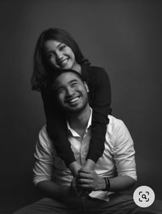 a black and white photo of a man holding a woman