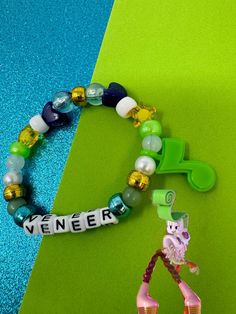 a beaded bracelet with an animal figure and name tag on it next to a toy horse