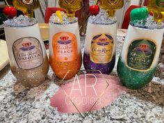 four different types of wine bottles sitting on top of a marble counter with ice in them