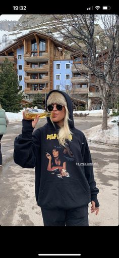 a woman in a black hoodie eating food