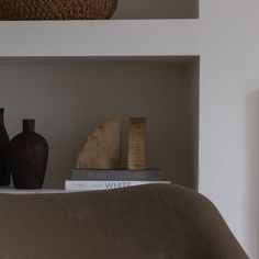 a shelf with books and vases on it