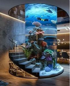 an aquarium in the middle of a spiral stair case with fish and corals on it