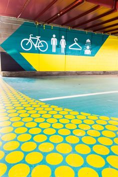 a yellow and blue floor with circles painted on it in a parking garage next to a sign