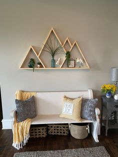 a white couch sitting in front of a wall mounted shelf filled with potted plants