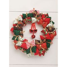 a christmas wreath with bells and bows on the front of it, hanging on a wall