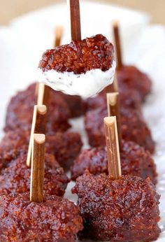 several skewered meatballs with toothpicks sticking out of them on a white plate