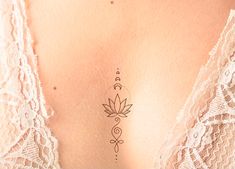 the back of a woman's stomach with a lotus tattoo on her left side